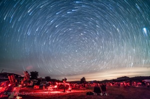 Circumpolar star trails over the upper field of the Texas Star Party, May 13, 2015. The star party attracts hundreds of avid stargazers to the Prude Ranch near Fort Davis, Texas each year to enjoy the dark skies. The three observing fields are filled with telescopes from the basic to sophisticated rigs for astrophotography. I aimed the camera to look north over the field to capture the stars circling around Polaris in circumpolar trails over about 1 hour. Some cloud and haze obscured parts of the sky. Lights from cities to the north add the sky glow at right. The streaks at top are from the stars of the Big Dipper. This is a stack of 55 exposures, each 1 minute long, at f/2.8 with the 14mm lens and Canon 5D MkII at ISO 3200. The foreground comes from a single image in the series, masked and layered in Photoshop. The images were stacked using the Long Trails tapering effect with the Advanced Stacker Actions from Star Circle Academy.