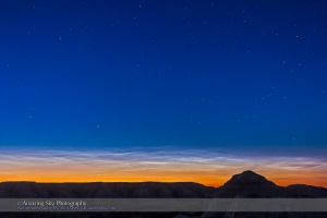 Noctilucent clouds (NLCs) over the silhouette of the badlands of Dinosaur Provincial Park in southern Alberta, on the night of June 15/16, 2015. The clouds remained low on the northern horizon and faded as the Sun angle dropped through the night but then reappeared in the northwest prior to dawn. The bright star at left is Capella, circumpolar at this latitude of 50° N.  This is a single exposure for 10 seconds at f/3.2 with the 16-35mm lens and at ISO 800 with the Canon 60Da.