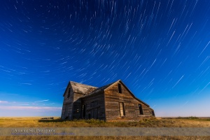 Circumpolar star trails circling above an old rustic and abandoned house near Bow Island, Alberta, with illumination from the nearly Full Moon. Cassiopeia is near centre. Polaris is at top left.  This is a stack of 140 frames from a time-lapse sequence with additional frames added for the first and last stars, and the ground coming from a mean combine stack of 8 frames to reduce noise. Each frame is 10 seconds at f/4 with the 16-35mm lens and ISO 1600 with the Canon 6D. Stacked with Advanced Stacker Actions, using the Ultrastreaks effect, from within Photoshop.