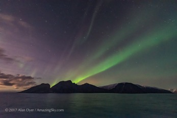 A dim but photogenic aurora on November 7, from the coast of Norway on the Hurtigruten ship the m/s Nordlys, in a view looking south to Pegasus and Andromeda, and over off-shore islands. The rising waning Moon off frame to the left illuminates the sky and landscape. This is a single 1-second exposure with the Sigma 14mm Art lens at f/1.8 and Nikon D750 at ISO 6400.