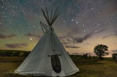 The Big Dipper and Arcturus (at left) over a single tipi at the Two Trees site at Grasslands National Park, Saskatchewan, August 6, 2018. This is a stack of 10 exposures, mean combined to smooth noise, for the ground, and one untracked exposure for the sky, all 30 seconds at f/2.8 with the 20mm Sigma lens and Nikon D750 at ISO 6400. Light cloud passing through added the natural star glows, enlarging the stars and making the pattern stand out. No soft focus filter was employed, and illumination is from starlight. No light painting was employed. Some airglow and aurora colour the sky. A Glow filter from ON1 Photo Raw applied to the sky to further soften the sky.