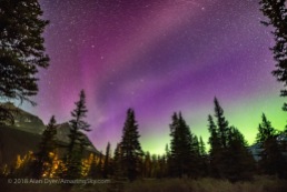 The unusual STEVE auroral arc across the northern sky at Bow Lake, Banff National Park, Alberta on the night of July 16-17, 2018. The more normal green auroral arc is lower across the northern horizon. But STEVE here appears more pink. The STEVE aurora was colourless to the eye but did show faint fast-moving rays, here blurred by the long exposure. They were moving east to west. The Big Dipper is at left. The lights are from Num-Ti-Jah Lodge. This is a single exposure for the sky and a mean-stacked blend of 3 exposures for the ground to smooth noise. All 15 seconds at f/2 with the Sigma 20mm Art lens and Nikon D750 at ISO 6400.