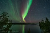 A faint green and red auroral curtain to the northwest over Tibbitt Lake on the Ingraham Trail near Yellowknife, NWT. The Big Dipper is right of centre; Arcturus setting on the horizon. This was September 8, 2018. This is a mean-combined stack of 8 exposures for the ground and water to smooth noise, and a single exposure for the sky, all 25 seconds at f/2 with the 15mm Laoawa lens and Sony A7III at ISO 1600.