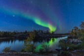 A display of Northern Lights starting up in the twilight, over the river leading out of Tibbitt Lake, at the end of the Ingraham Trail near Yellowknife NWT, on September 8, 2018. This was the start of a fabulous display this night. Capella and Auriga are at left; the Pleiades is rising left of centre; the Andromeda Galaxy is at top. This is a mean-combined stack of 7 exposures for the ground to smooth noise and one exposure for the sky and partially for the reflection, all 25 seconds at f/2.5 with the 14mm Sigma Art lens and Nikon D750 at ISO 1600.
