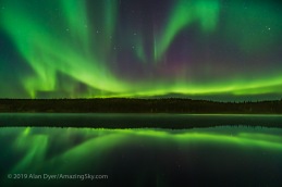 Reflections of the Northern Lights in the calm and misty waters of Madeline Lake on the Ingraham Trail near Yellowknife, NWT on Sept 7, 2019. This is one of a series of “reflection” images. The Big Dipper is at left. Capella is at right. This is a single 13-second exposure with the 15mm Laowa lens at f/2 and Sony a7III at ISO 1600.